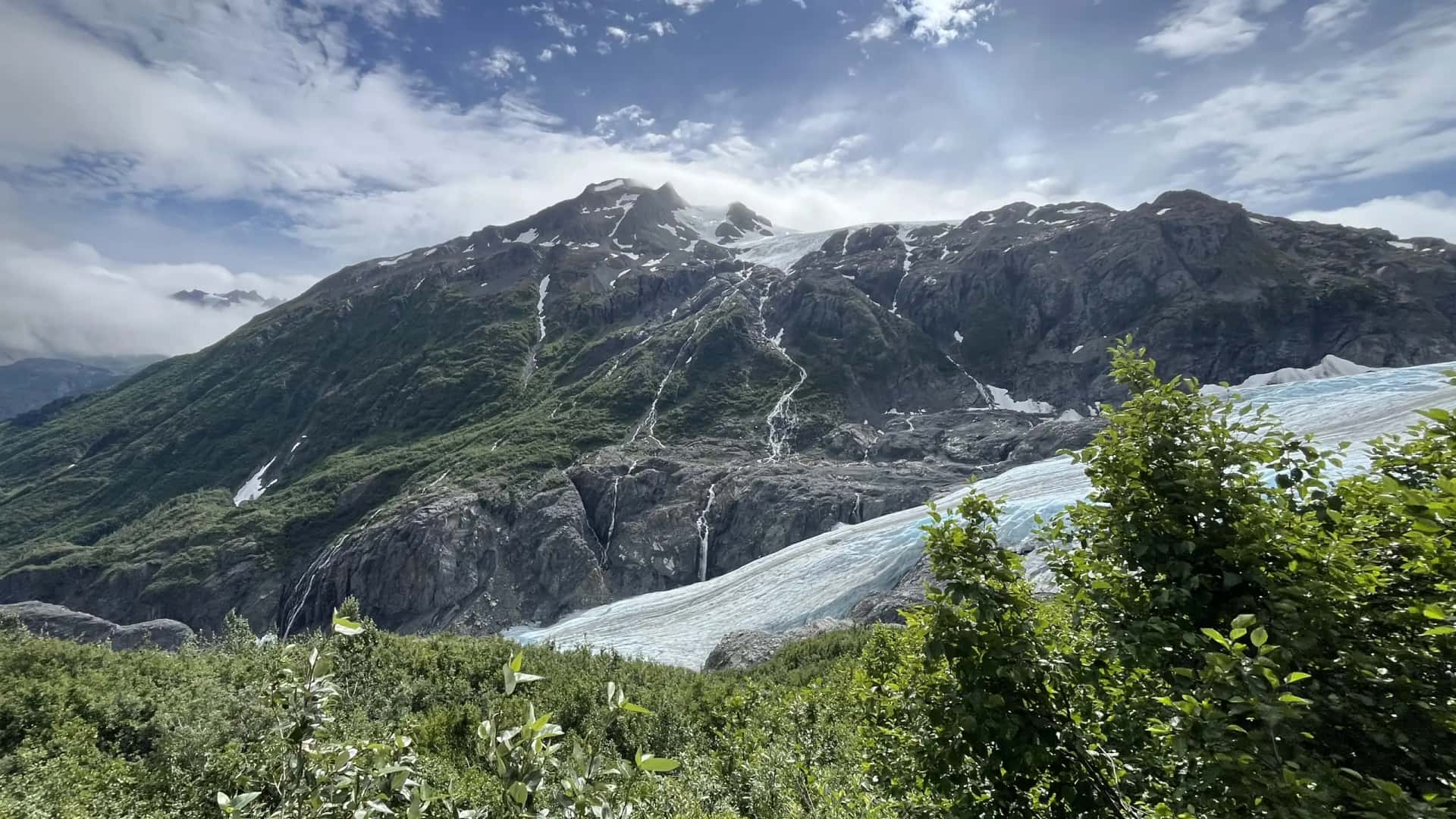 Sweeping aerial view of a glacier winding through snow-covered mountains near McCarthy, Alaska