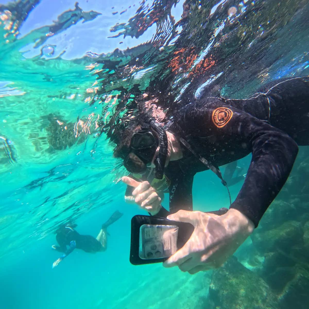 Tour participant snorkeling underwater in wetsuit during Santa Cruz Island tour excursion Galapagos Islands Ecuador GoPro photo