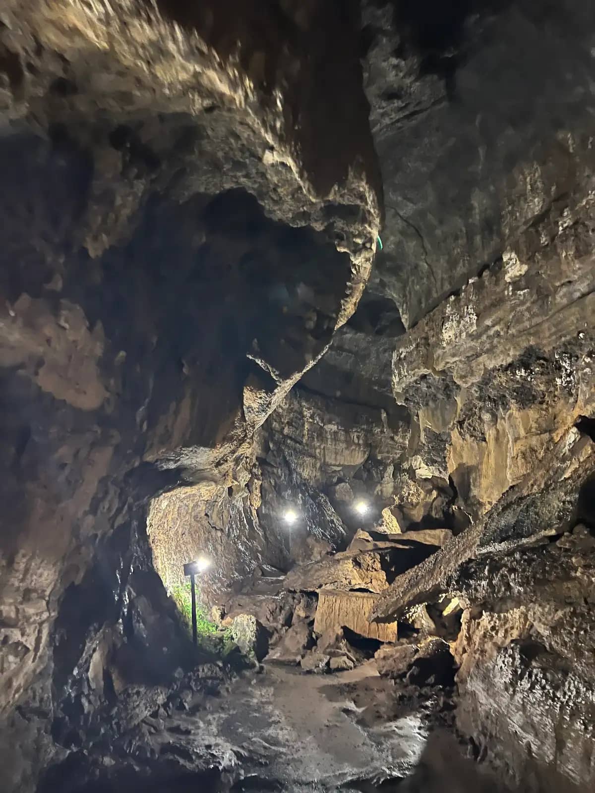 Interior of lava tunnel cave with illuminated volcanic rock walls on Santa Cruz Island Galapagos Islands Ecuador transfer-in tour