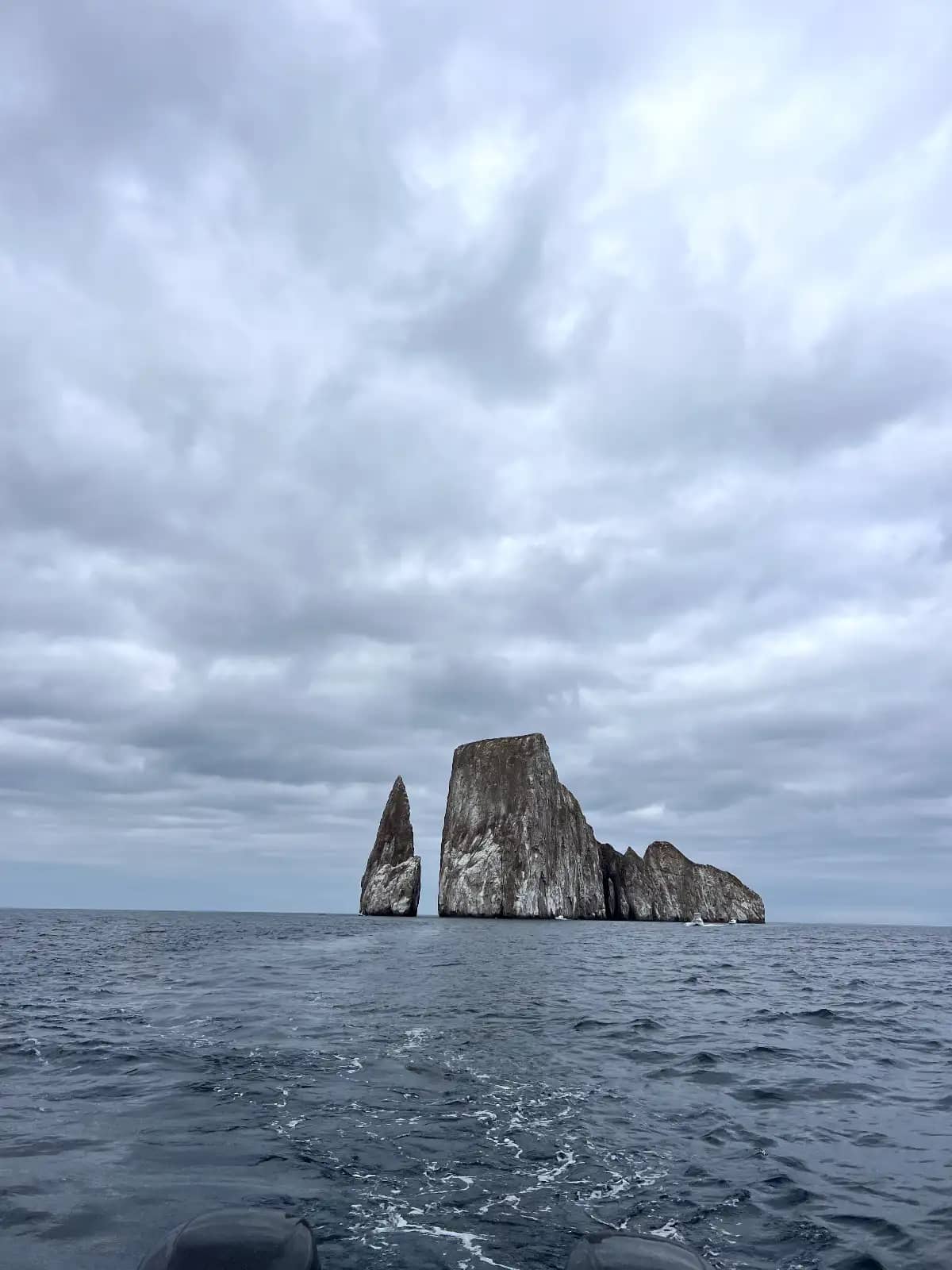 Kicker Rock sea stack rising from ocean under cloudy sky during 360 tour San Cristobal Island Galapagos Islands Ecuador